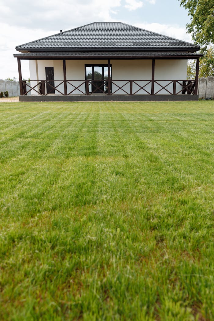 about-01 A modern house with a large freshly mowed lawn ideal for real estate or gardening themes.